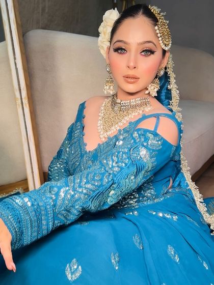 Another pose in the teal blue lehenga, highlighting the intricate silver work on the blouse.