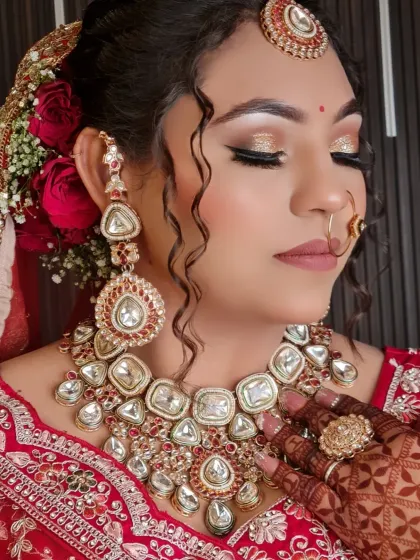 A close-up of this gorgeous bride's makeup. The glittery gold eyeshadow and perfectly winged liner complement her red outfit and kundan jewelry beautifully.