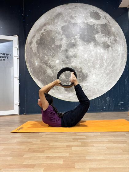 Using the yoga wheel to move into a full Dhanurasana (Bow Pose), this student shows how props can help achieve advanced postures.