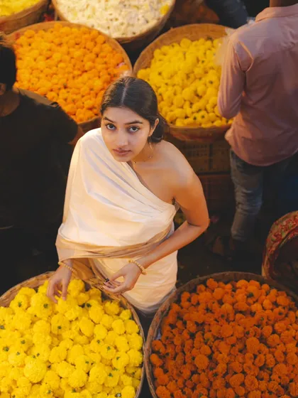 An overhead shot in the flower market, surrounded by baskets of marigolds. This perspective offers a unique and colorful view of the scene.