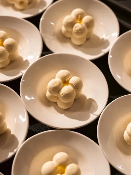 A beautiful dessert made of small, interconnected spheres of mousse. The geometric arrangement and clean presentation make it a piece of edible art.