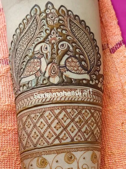 A close-up of a beautiful cuff design featuring two parrots, showcasing the variety of bird motifs we can create.