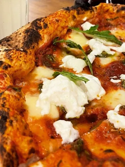 Take a close look at the textures on my Pesto Burrata pizza. You can see the creamy, fresh burrata, the vibrant pesto, and the light, airy crust with its signature char. This is a crowd favorite for a reason.