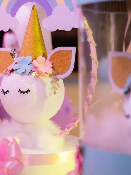 A close-up of the adorable unicorn centerpiece, crafted with a styrofoam ball, paper flowers, and a golden horn.