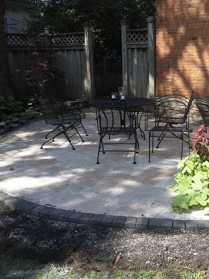 Even a small, unused corner of a yard can be turned into a useful space. This simple circular patio is just big enough for a small table and chairs.
