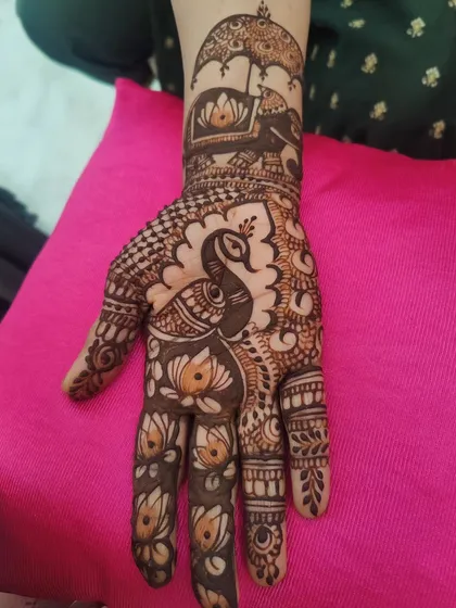 A beautiful design for the groom's mother, featuring a peacock and an elephant with a royal umbrella.