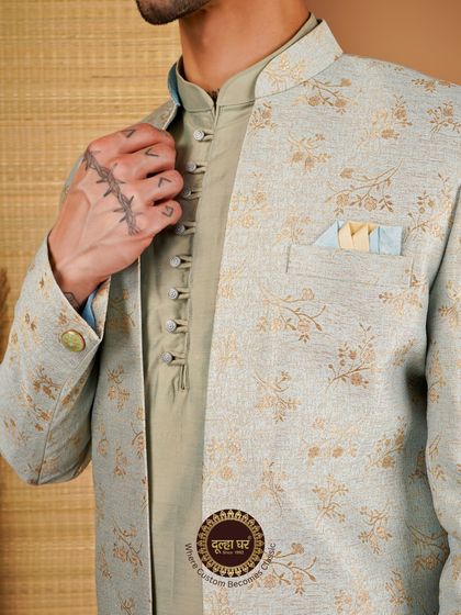 Where custom becomes classic. A detailed shot of a light green Indo-Western jacket, highlighting the fabric's floral pattern and the kurta's button placket.