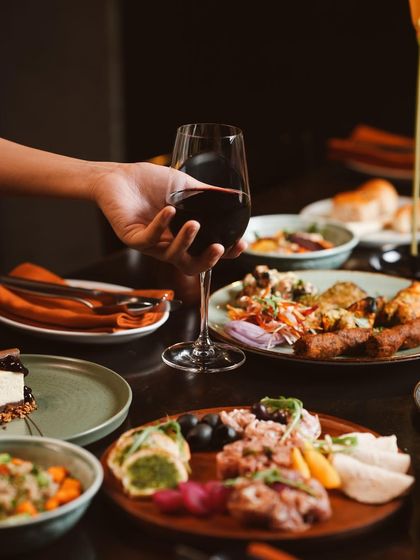 A toast to the perfect Sunday. A glass of red wine complements the rich flavors of our brunch, which includes a variety of grilled meats, fresh salads, and artisanal platters.