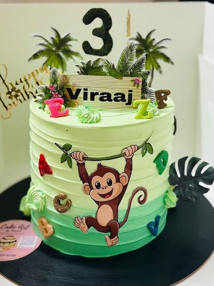 A cute monkey-themed cake with alphabet blocks, perfect for a jungle-loving child.