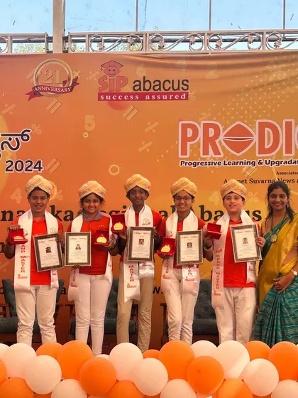 Another group of our accomplished graduates on stage, proudly displaying their medals and certificates from the regional abacus competition.
