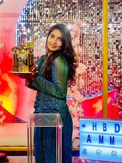 The birthday girl holds her stunning cake, posing in front of a beautiful pink and gold sequin backdrop. Our spaces are designed to make you and your celebration shine.