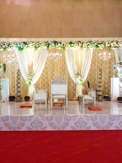 This elegant stage for Aashna and Bhargav's wedding featured a backdrop of cream drapes and a gold lattice, with traditional silver pillars adding a touch of heritage.