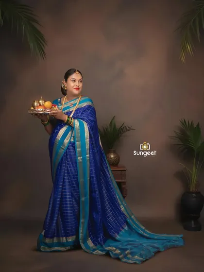 Holding a traditional thali, this mom-to-be looks radiant. We use props to add cultural significance to our saree maternity photoshoots.
