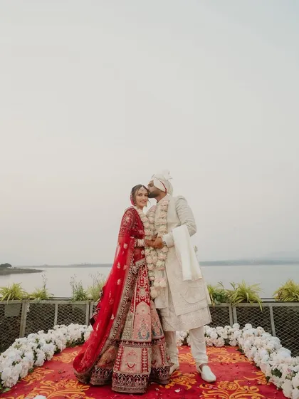 A tender forehead kiss against the serene backdrop of a lake. We help couples find the perfect destination and venue for a wedding that feels both grand and intimate.
