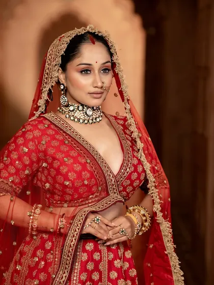 See how my rental jewellery completes the bridal look. This bride is wearing a statement Kundan and pearl choker set, which pairs beautifully with her red wedding lehenga.