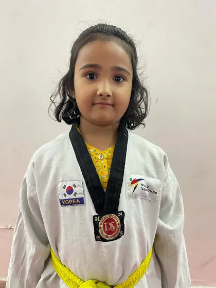 A future star. This little girl proudly wears her medal, a sign of her early success in the world of Taekwondo.