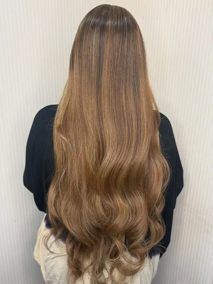 The full view of this stunning long, blonde, and wavy balayage. It’s a timeless look that is always in style.