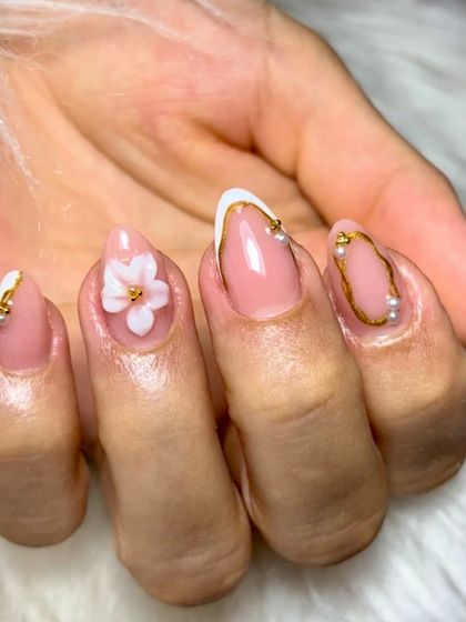 Less loud, more luxe. This clean and elegant set features a soft blush base, delicate gold lines, tiny pearls, and a single 3D floral accent. It's the definition of bridal chic.