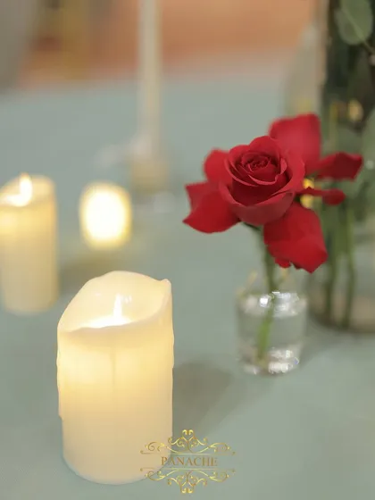 A close-up of a single red rose and a flickering candle, small details that create a big impact.