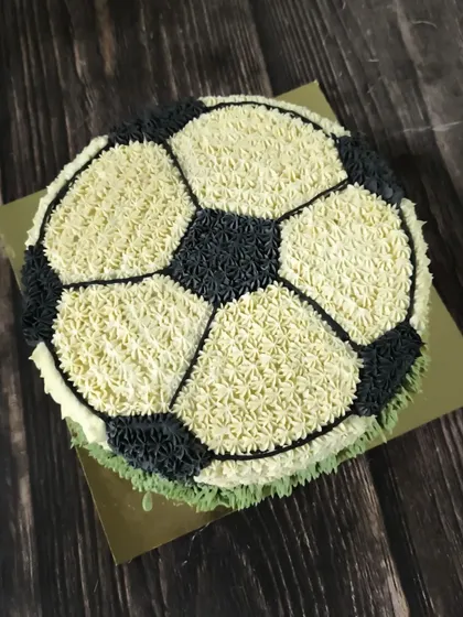 This all-buttercream football cake was so much fun to create. I used a star piping tip to make tiny dollops of black and white frosting, building up the classic soccer ball pattern for a true sports fan's celebration.