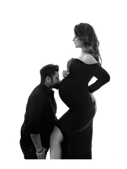 A classic pose filled with love and tenderness. This black and white silhouette shot is a powerful way to capture the bond between a partner and the baby bump.