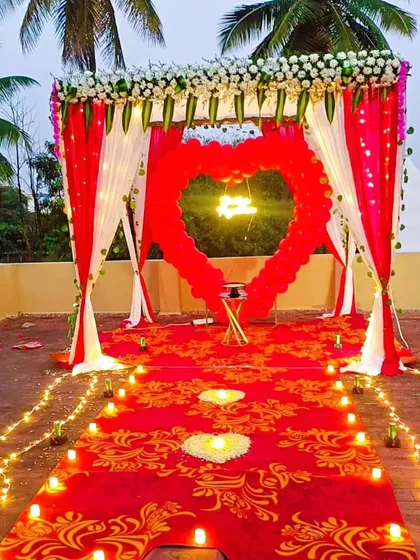 I design unforgettable proposal setups like this one, featuring a candle-lit path leading to a heart-shaped balloon arch and a custom neon sign, creating the perfect romantic moment.