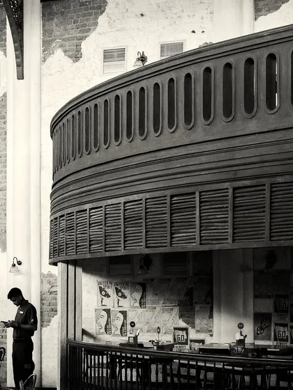 The massive, curved balcony structure overhangs a smaller bar area below, showcasing the complex, multi-level design.