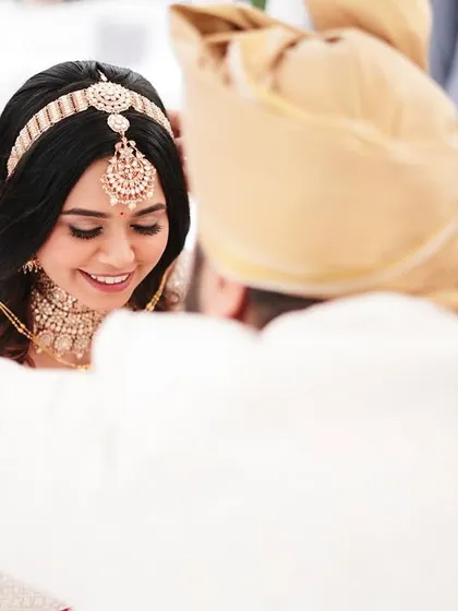 A tender moment during the ceremony. The groom's gentle touch and the bride's happy smile speak volumes about their connection.