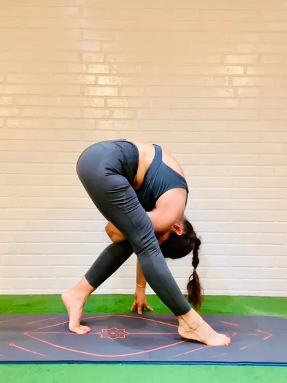 Parivrtta Trikonasana, or Revolved Triangle Pose, in a forward fold variation. In yoga, we fold not to shrink, but to surrender the ego and connect with the humility and grounding force of the earth.