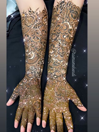 A full view of a sparkling, glittery full-arm mehendi design, perfect for a glamorous bridal look.