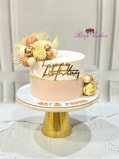 An elegant and classy birthday cake for 'Aai & Pappa', adorned with soft pastel tones, delicate roses, and golden accents.