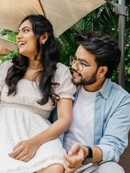 A candid and joyful moment captured while the couple relaxes on a lounge chair outdoors. Their natural laughter and interaction make this a perfect memory.