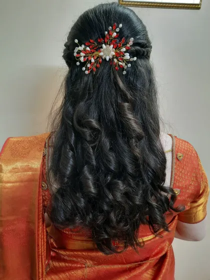 This is a great example of a modern hairstyle for a reception or pre-wedding event. I created soft, bouncy curls and a half-up twist, finished with a delicate hair accessory for an elegant and romantic feel.
