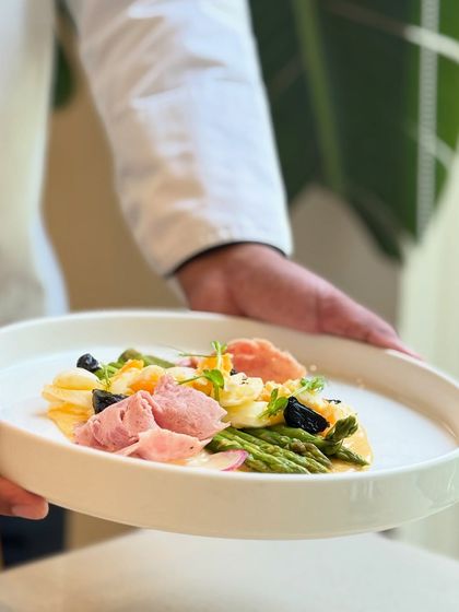 A chef presents our seasonal Himalayan asparagus dish. The vibrant green of the asparagus, sourced from our own farm and the Chamba region, makes for a beautiful and delicious plate.