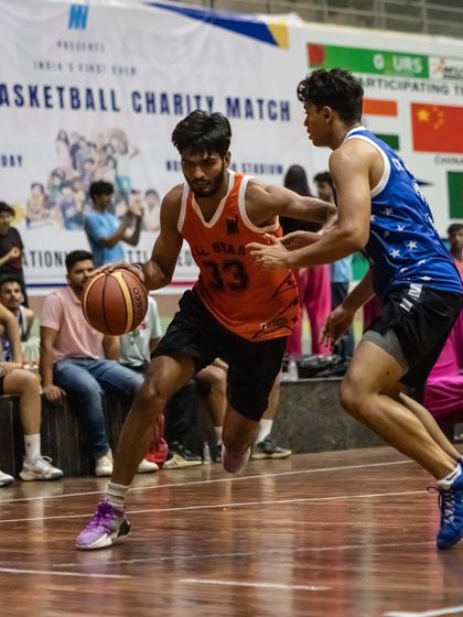 A player skillfully dribbles past a defender during a fast-paced charity match. These events allow players to test their skills against diverse opponents in front of a live audience.