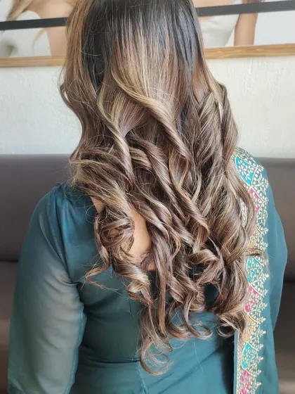 This balayage with tight curls is perfect for a party or special event, showcasing the beautiful blend of colors.
