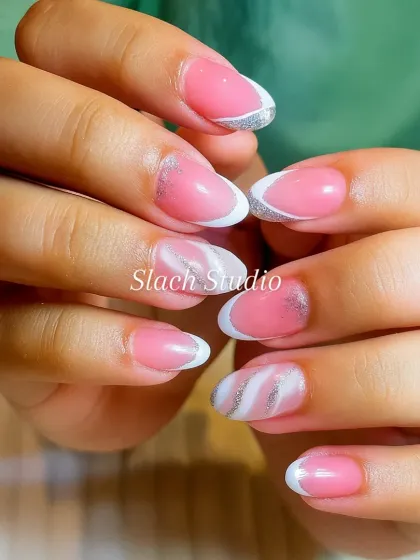 I created this elegant French manicure on natural almond-shaped nails. It features a soft pink base, classic white tips, and a subtle silver glitter line, with a white marble swirl on the ring finger for a unique accent.