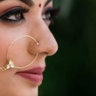 Every detail matters. This artistic shot highlights a beautifully defined eye and a traditional nose ring, showcasing how makeup and jewelry work together to create a complete, stunning bridal profile.