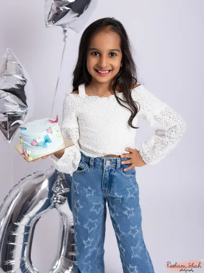 Celebrating a perfect 10! This birthday girl is all style and smiles, holding her cake in a chic and modern studio setup.