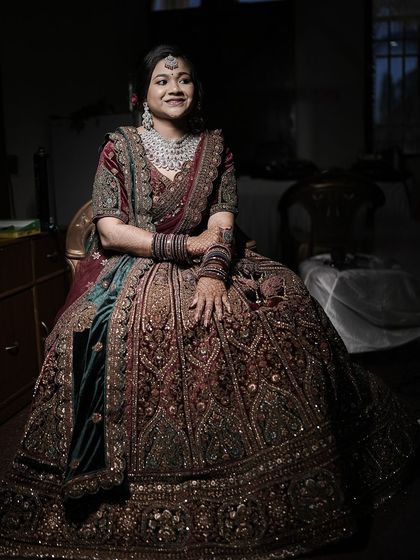 A stunning portrait of a bride in a heavily embroidered lehenga, seated elegantly for her reception. This showcases my work with modern and North Indian wedding styles.