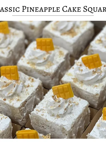 Classic Pineapple Cake squares. This nostalgic dessert is light, airy, and topped with fresh cream and a small piece of pineapple-flavored white chocolate.