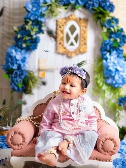 A sweet baby Krishna dressed in pink, sitting happily on his little sofa. We offer a variety of colorful outfits for both boys and girls.