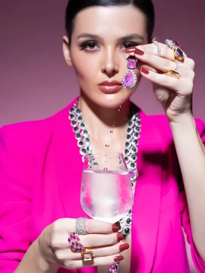 A conceptual beauty shot for a jewellery campaign. The bold pink blazer and creative use of water create a modern, artistic context for the precious stones, showing that jewellery styling can be highly imaginative.