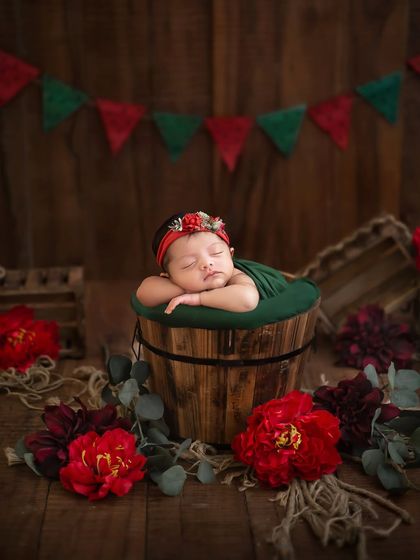 A rustic and festive theme, combining a wooden backdrop with rich red and green florals and fabrics to create a warm, cozy atmosphere.