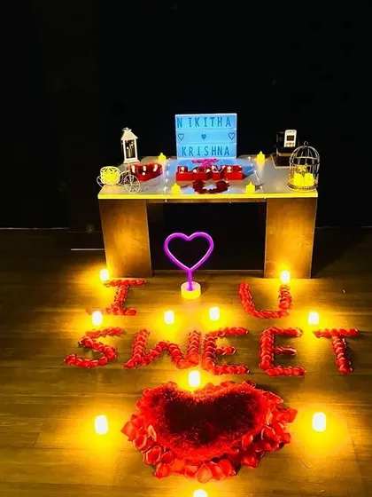 The ultimate romantic gesture. The floor is decorated with candles and rose petals spelling out a sweet message, with a personalized lightbox and a neon heart setting the scene for a proposal or special date.