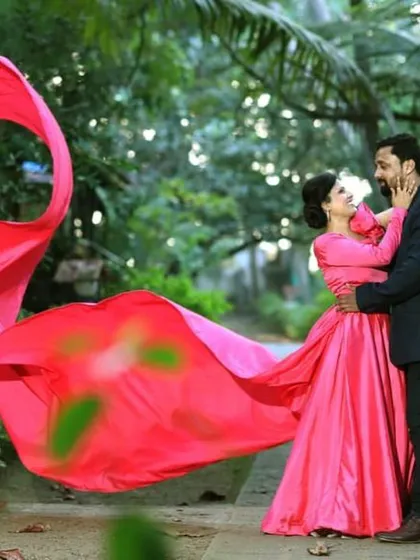 This bright pink trail gown adds a fun and vibrant pop of color to this couple's pre-wedding shoot. The fabric is designed to catch the air, creating beautiful, flowing shapes for your photos.