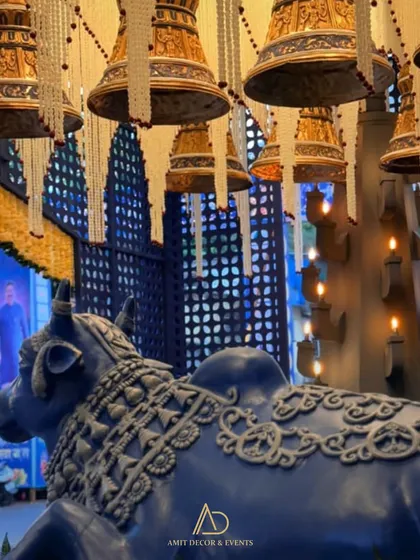 A side view capturing the grandeur of the entrance, with the ornate Nandi, hanging bells, and a custom wall with intricate patterns.