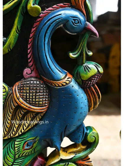 A close-up of a 24-inch colorful wooden peacock wall mount. The brilliant blues and greens are expertly applied to mimic the bird's natural beauty.