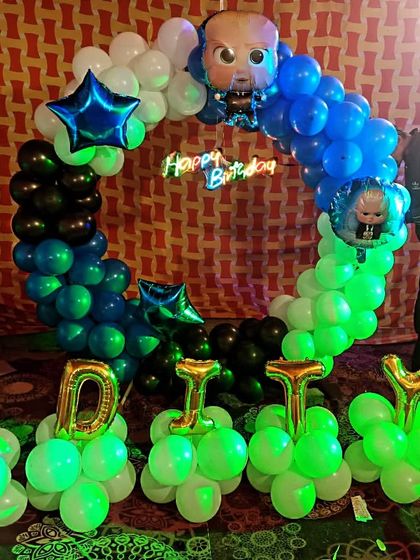 A 'Boss Baby' themed birthday party perfect for your little leader. The setup includes a balloon ring in shades of blue, green, and black, with character foil balloons and the birthday boy's name in large foil letters.