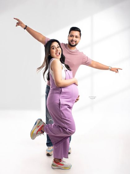 Capturing the fun and excitement of pregnancy with a playful pose. This couple's joyful energy is infectious, and the casual outfits show a different, more relaxed side of maternity photography.